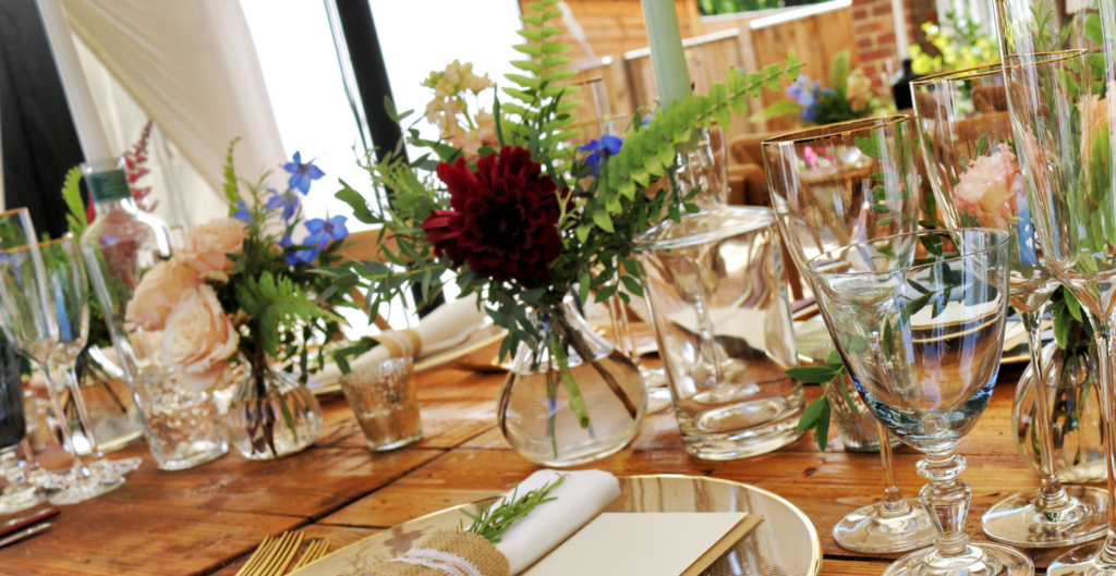 Dinner party table with flowers glasses and table settings